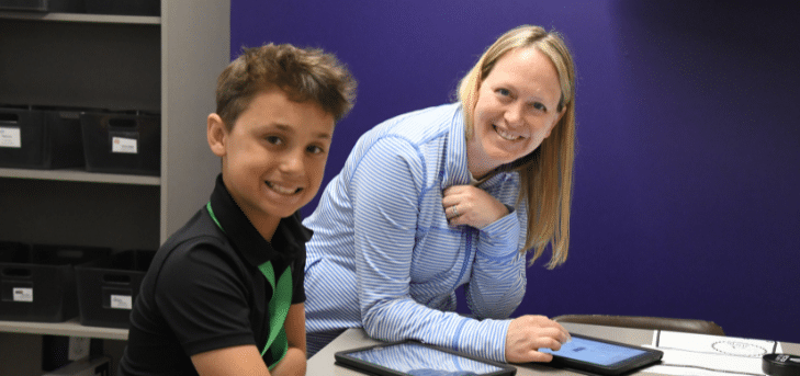 student and volunteer working together and smilng